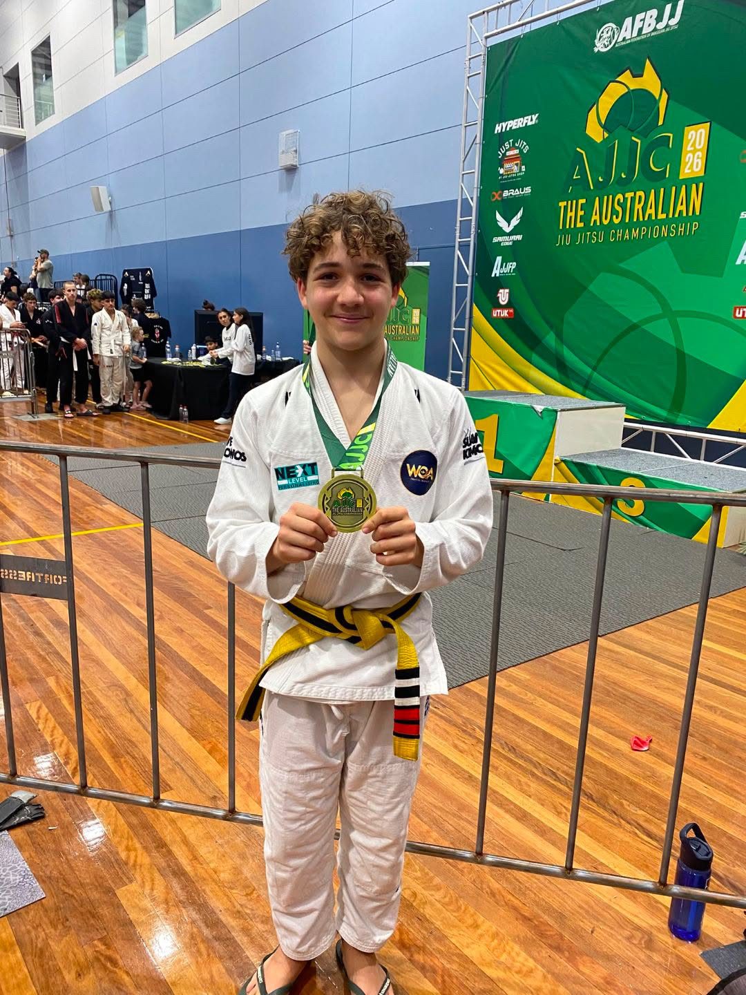 A young Legacy competitor with his gold medal at AJJC 2026