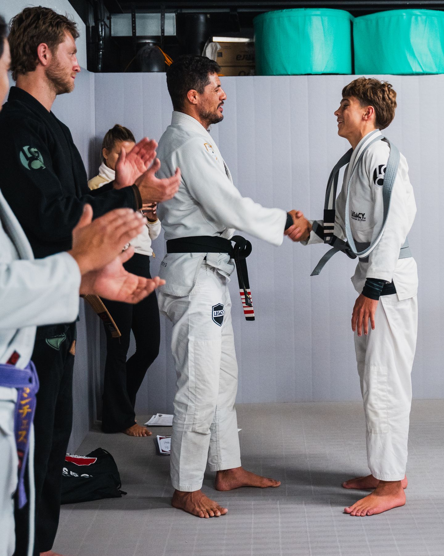 Belt promotion at Legacy Jiu Jitsu, coach and student shaking hands