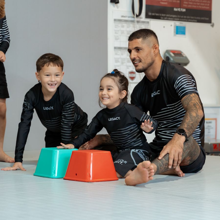 Coach engaging young children with equipment on the mats